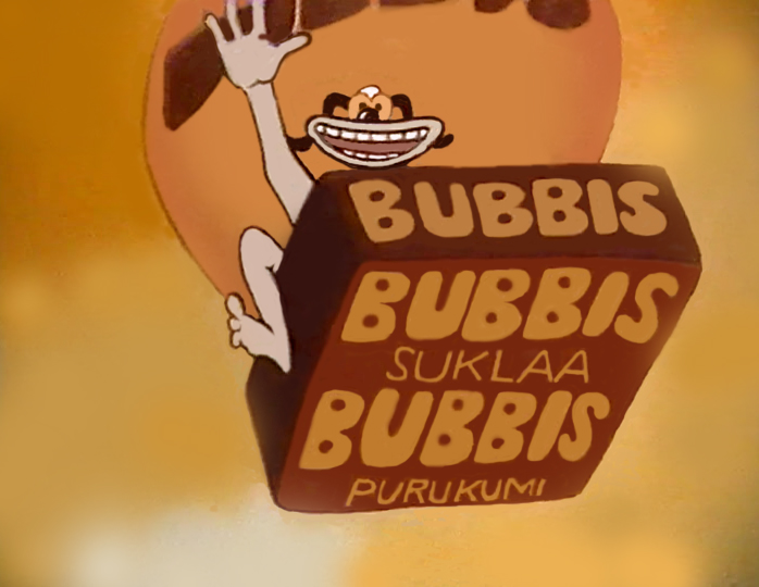 Kuva elokuvasta Suklaa Bubbis, hahmo vilkuttaa ja pitää ruskeaa pakkausta, jossa lukee BUBBIS SUKLAA BUBBIS PURUKUMI