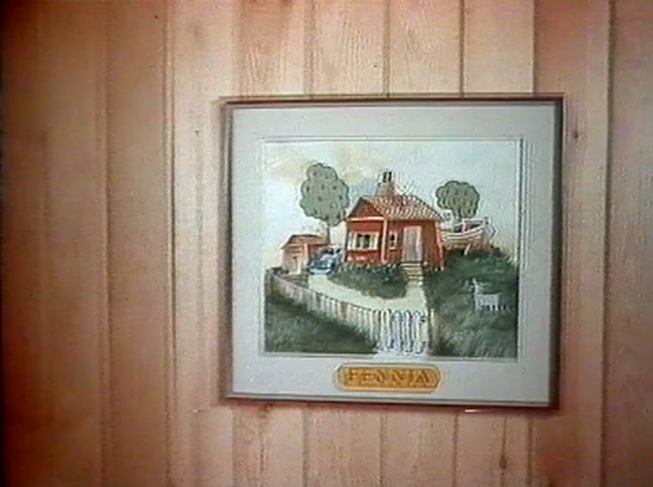 Mies kävelee punaisen puutalon polkua pitkin, talossa tiilikatto ja säleaita.