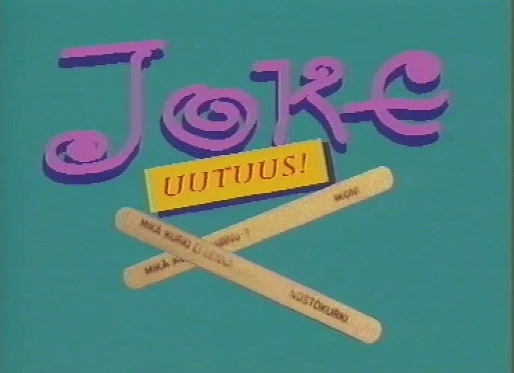 Joke-logo violetilla kaunokirjoituksella, alla UUTUUS!-läiskä ja kaksi ristikkäistä jäätelötikkua arvoituksineen.