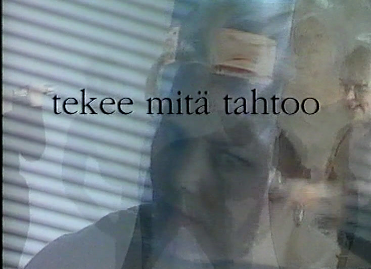 Vaaleahiuksinen nainen nauraa sälekaihtimen edessä tekstin tekee mitä tahtoo alla