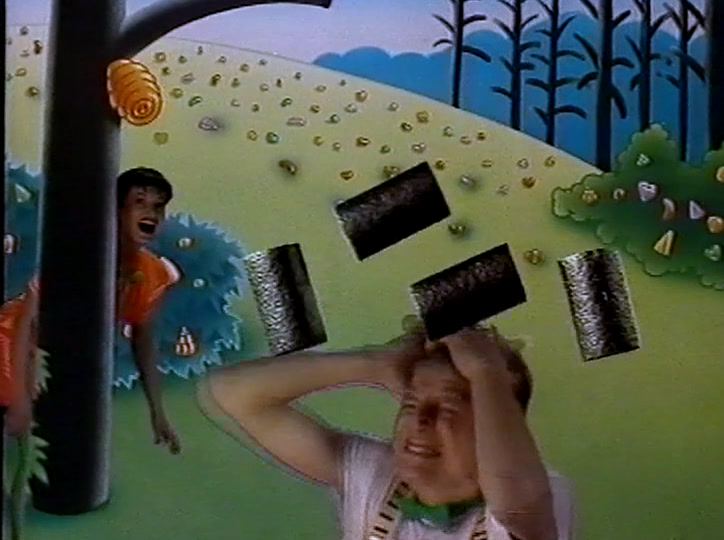 A man raises black liquorice slabs over his head while a woman shouts behind him.