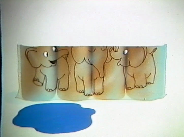 The roll pulled open across the frame, printed elephants running along the paper