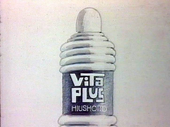 Uritettu valkoinen pullo, jossa lukee ViTa PLUS HIUSHOITO, seisoo vaaleaa taustaa vasten.