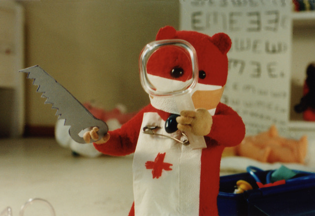 Still from Urpo and Turpo, Turpo in a surgeon's mask wielding a toy saw