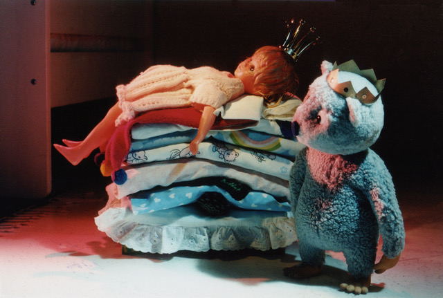 Still from Urpo and Turpo, Urpo beside a stack of folded laundry that has become the princess's mattresses
