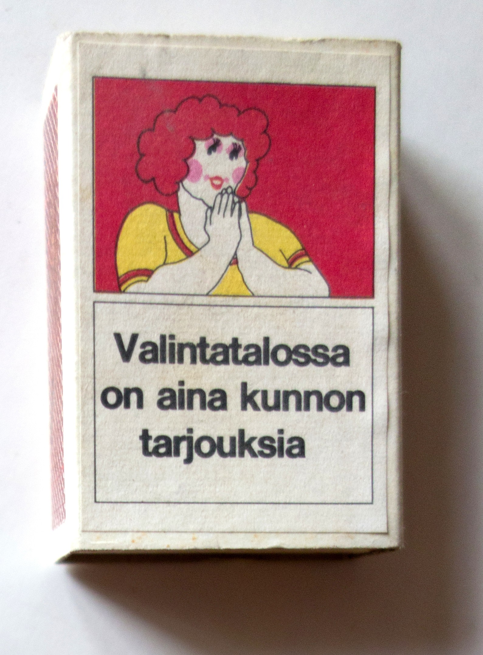 Valintatalon tulitikkurasia, jossa Hyvä tyttö -mainoksen nainen ja teksti Valintatalossa on aina kunnon tarjouksia.